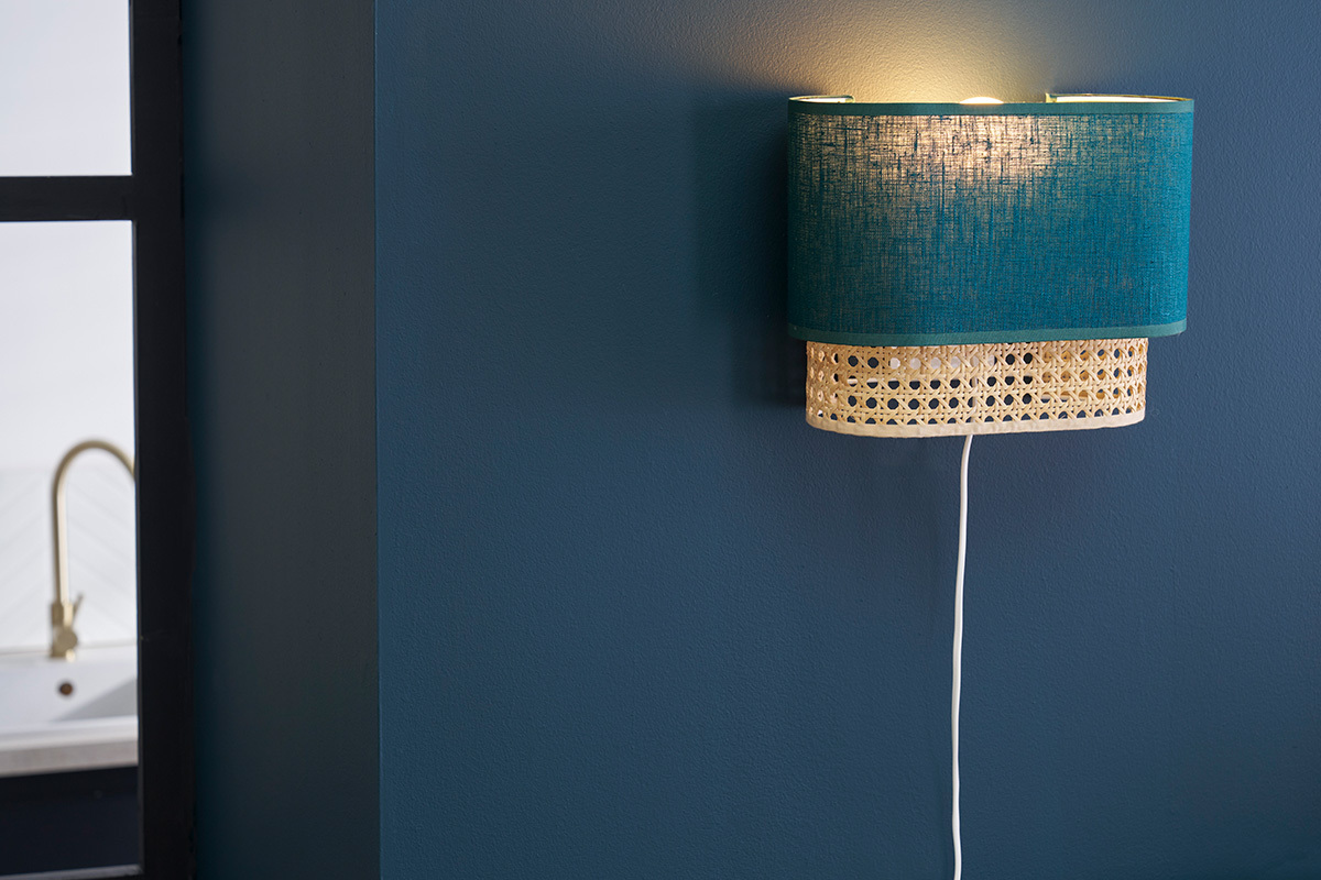 Applique murale bleu canard et rotin, vue de c�t�, sur mur bleu.
