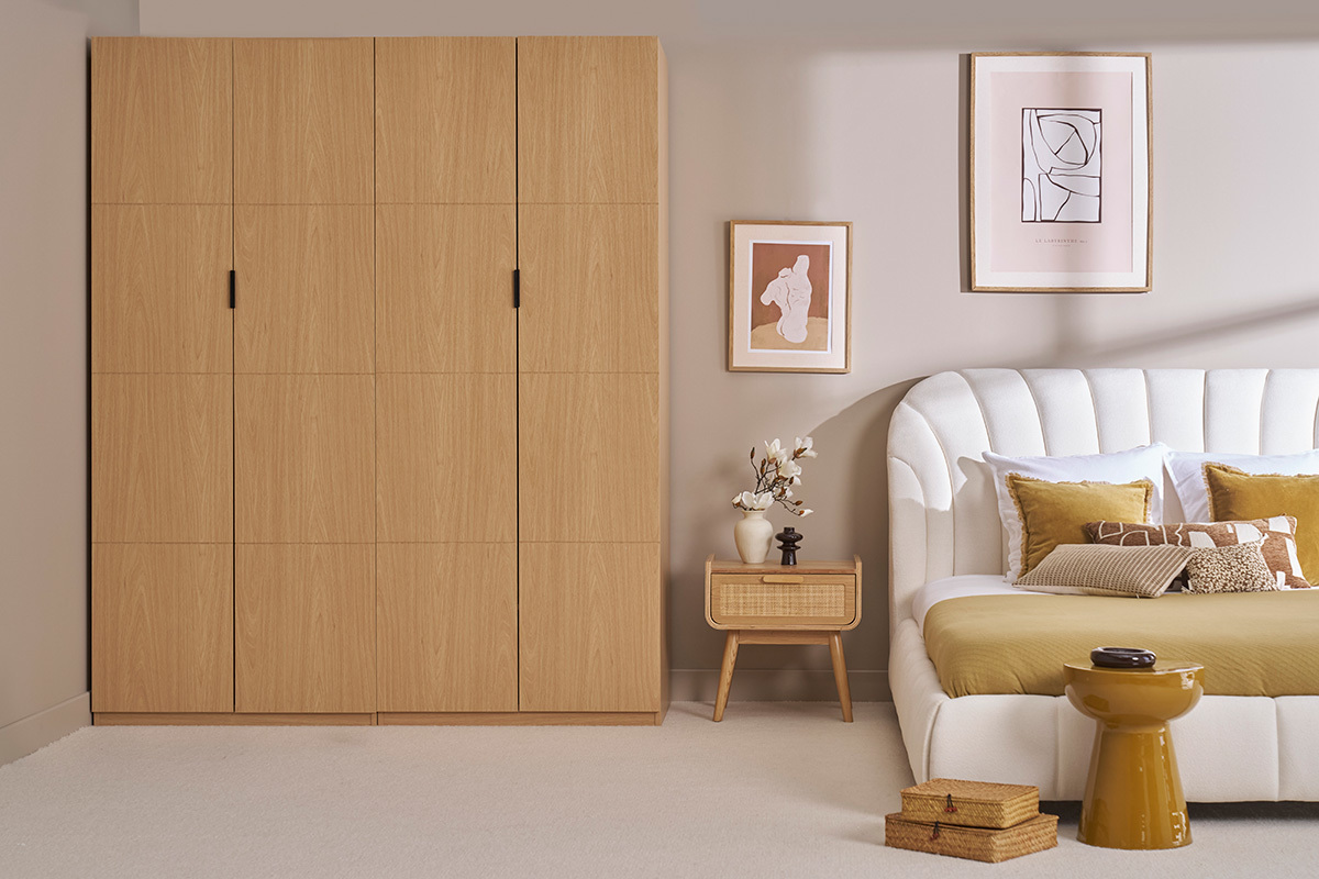 Armoire GARENCE en bois ch�ne clair � c�t� d'un lit et table de chevet.