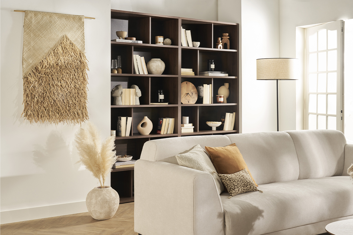 Biblioth�que design en bois fonc� avec 12 casiers derri�re un canap� clair.