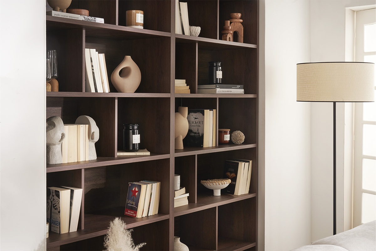 Biblioth�que bois fonc� avec livres et objets d�co, vue de c�t�.