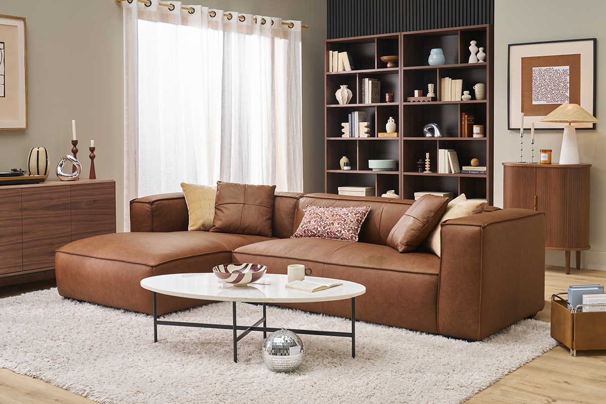 Salon avec biblioth�que bois fonc� � 12 casiers, canap� marron, table basse blanche et cadre d�coratif.