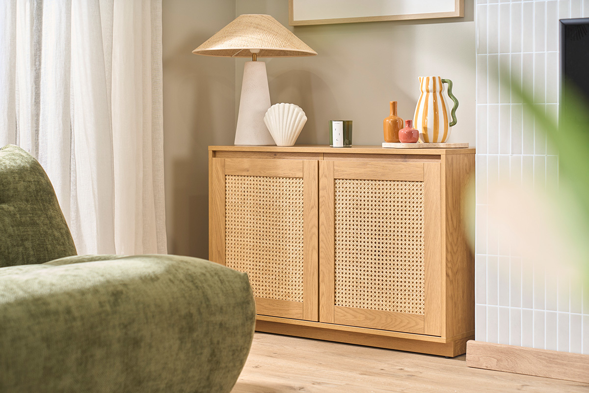 Buffet bas en bois clair ch�ne avec portes en cannage rotin, d�cor� d'objets sur le dessus