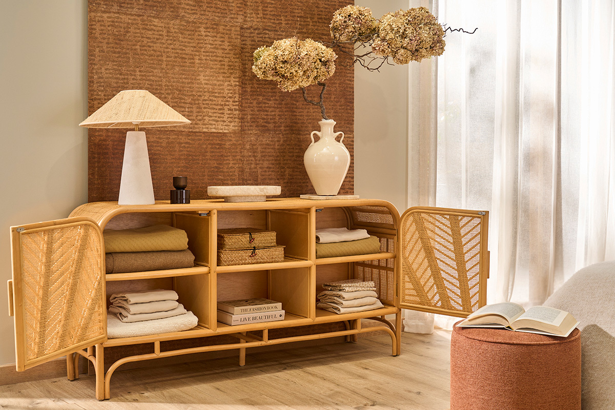 Buffet en rotin � deux portes ouvertes avec �tag�res, objets et d�coration.