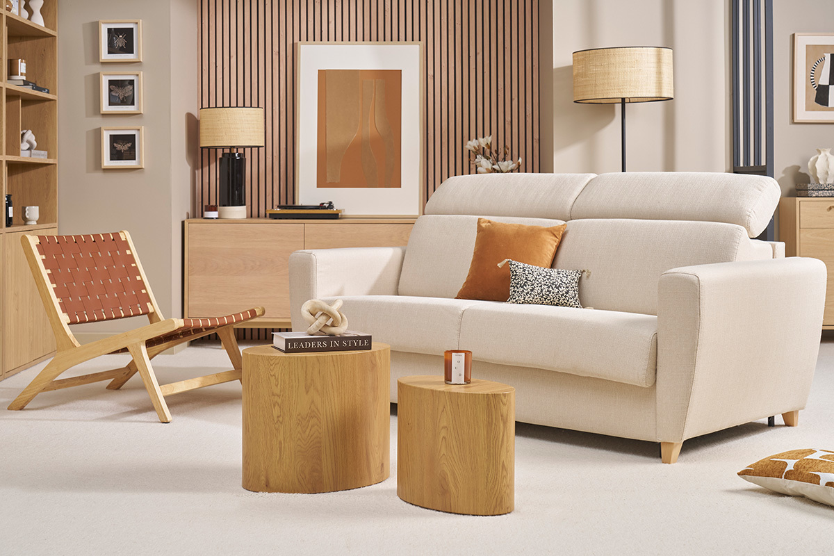 Canap� convertible beige GOYA avec t�ti�res ajustables, vue frontale, dans un salon avec meubles en bois clair.