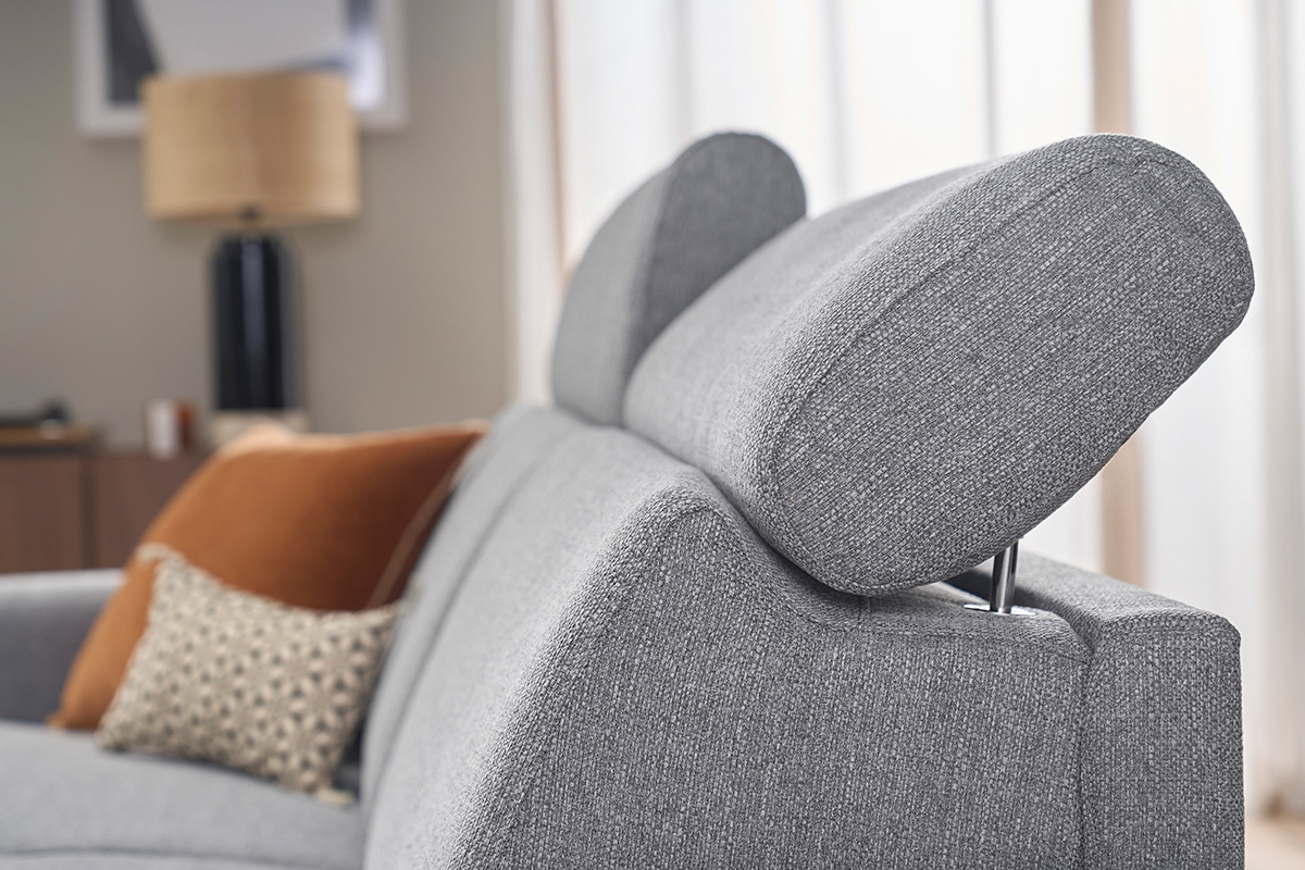 D�tail des t�ti�res ajustables d'un canap� convertible gris clair, avec coussins d�coratifs.