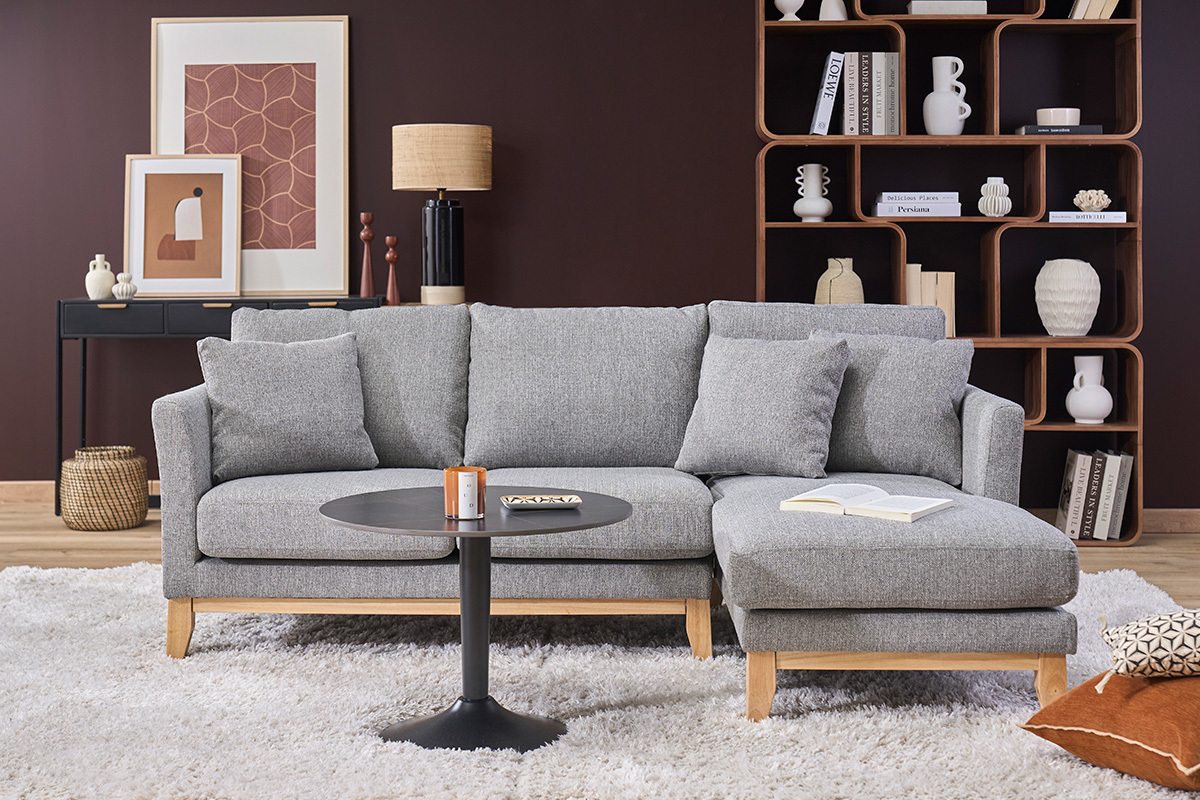 Canap� d'angle droit scandinave 4 places en tissu gris clair, avec coussins, sur tapis blanc