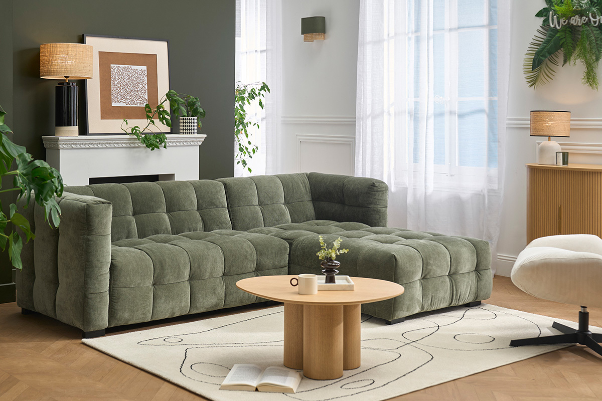 Canap� d'angle droit 3 places en tissu velours vert kaki, vue de 3/4 dans un salon moderne.