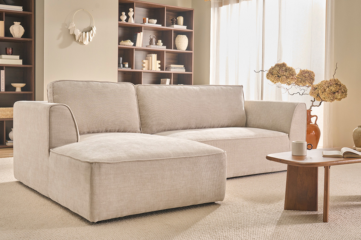 Canap� d'angle gauche beige 3 places GRAMMY en tissu effet velours, salon lumineux avec table basse en bois.