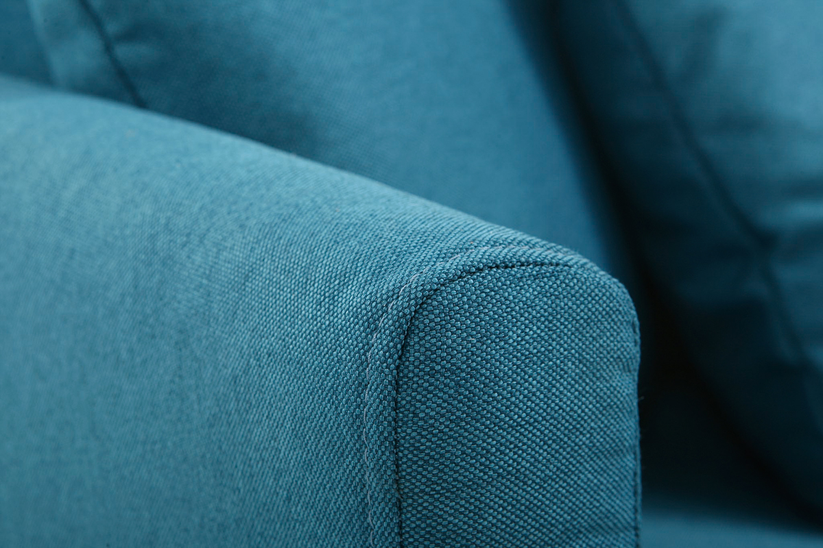 Gros plan d'un accoudoir de canap� scandinave en tissu bleu canard.