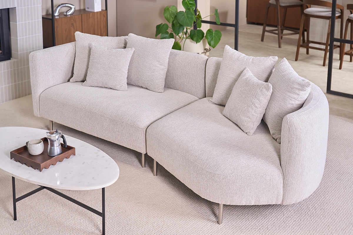 Canap� design 3-4 places en tissu effet velours beige clair avec accoudoirs arrondis, vue de 3/4.