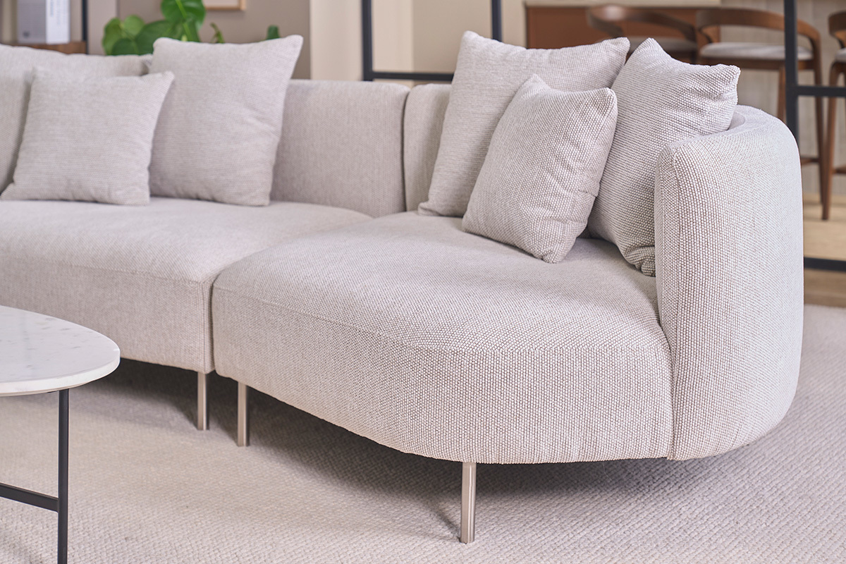 Canap� design 3-4 places en tissu effet velours chenill� beige clair avec coussins, vue de pr�s.