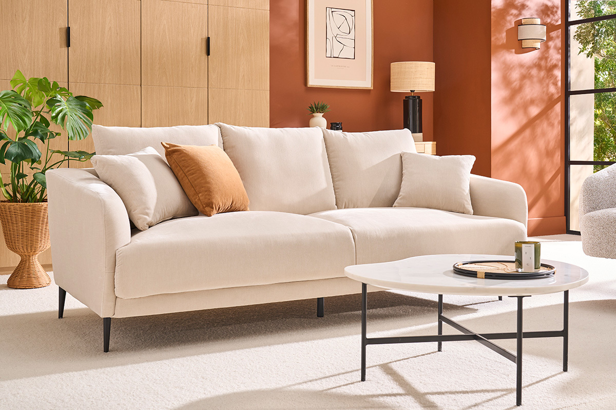 Canap� 3 places en tissu beige avec pieds en m�tal noir, vue de face avec table basse.