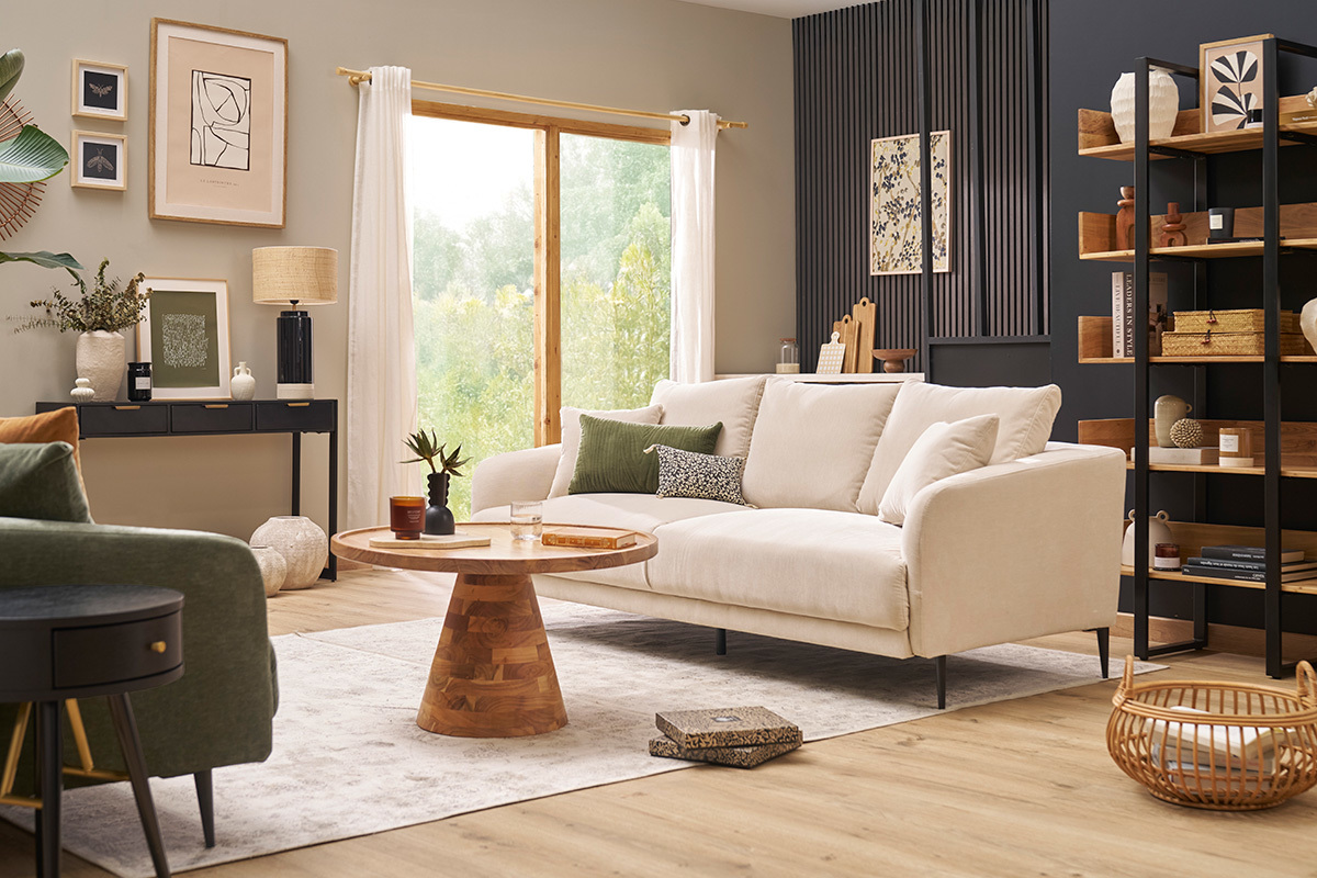 Canap� beige effet velours 3 places avec pieds noirs, dans un salon moderne avec table basse en bois.