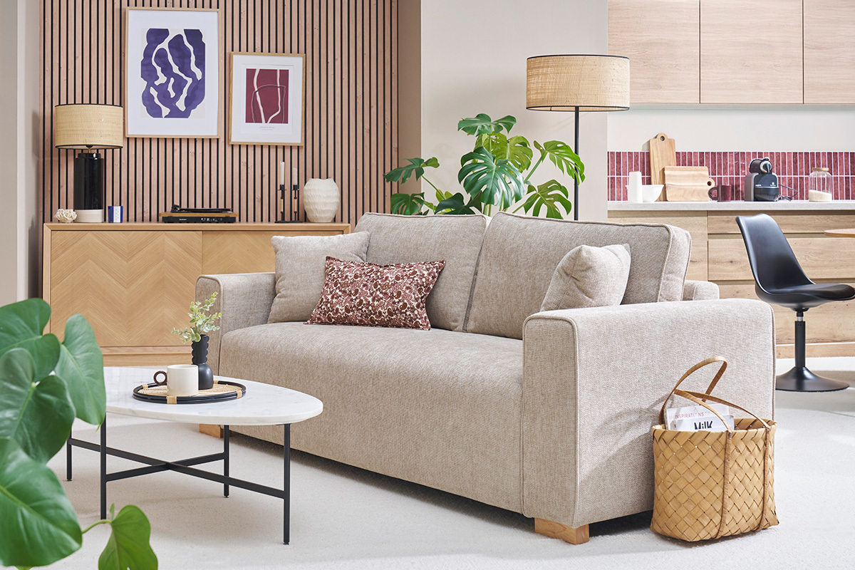 Canap� 3 places effet velours textur� beige, vue de 3/4 dans un salon d�cor�.