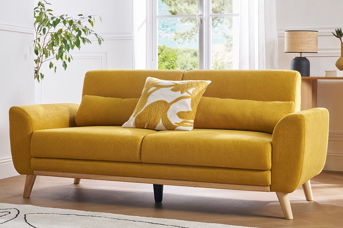 Canap� scandinave 3 places en velours jaune moutarde, vue de face, avec coussin d�coratif.