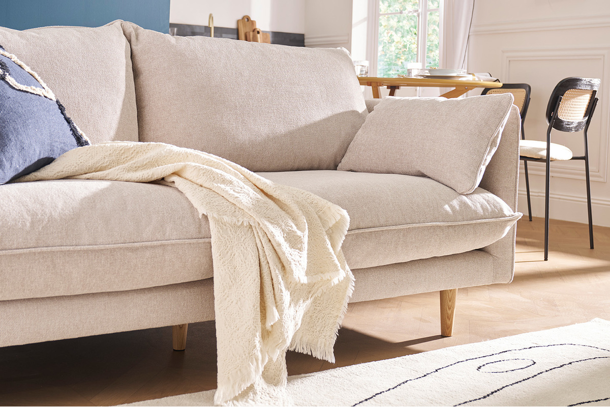 Canap� scandinave beige en tissu textur� avec coussins, vue de c�t�.
