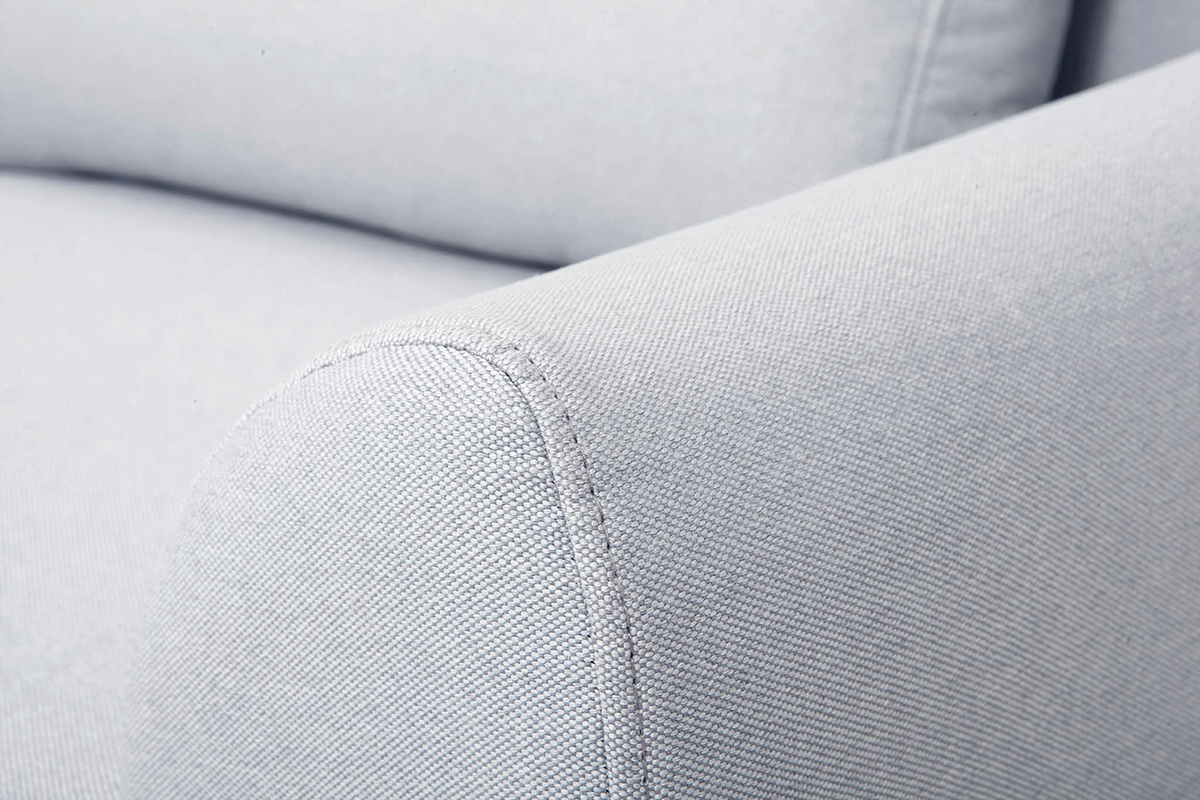 Gros plan sur l'accoudoir du canap� scandinave en tissu gris clair.