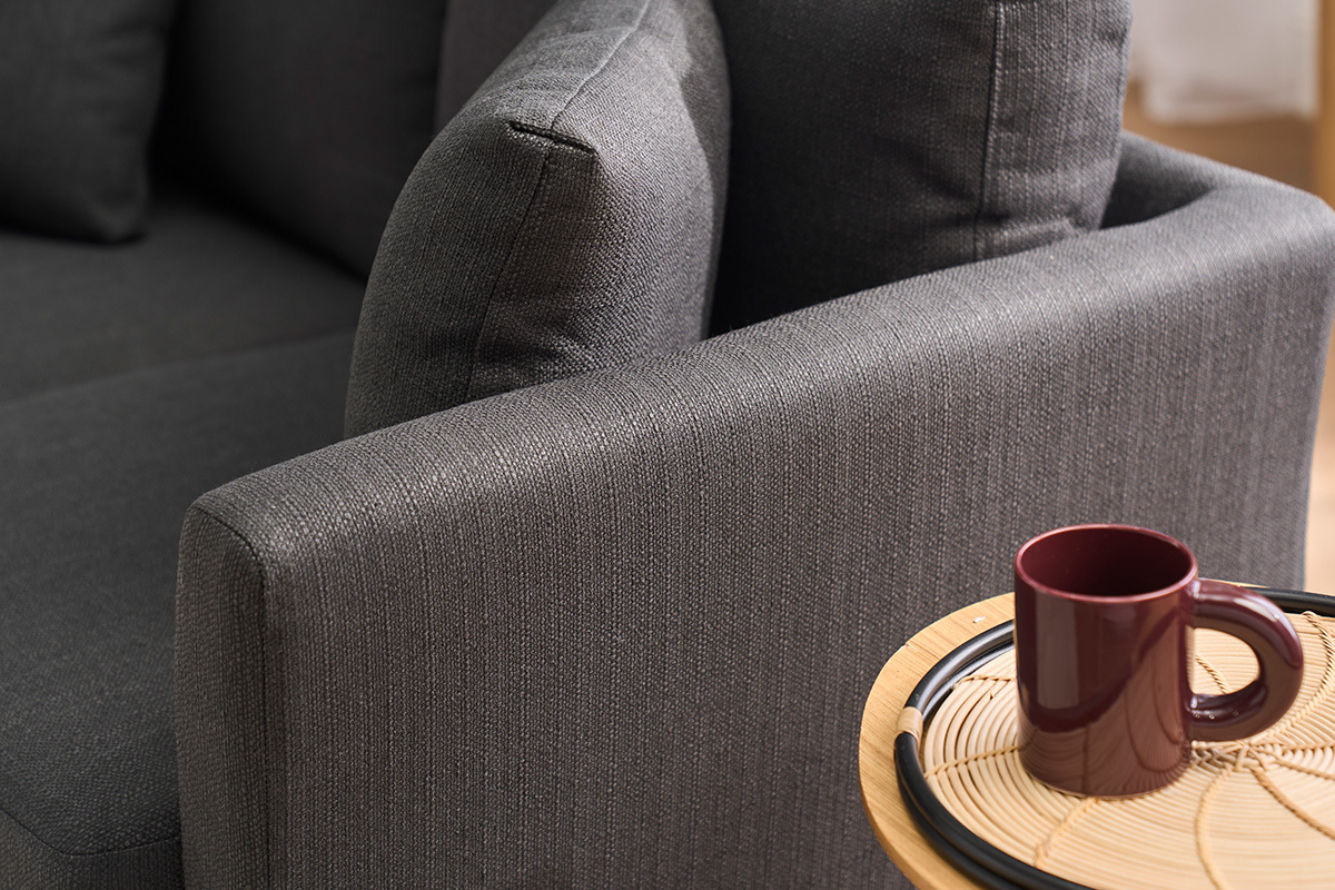 Canap� gris fonc� 2 places OSLO en gros plan avec une tasse sur une table en bois clair.