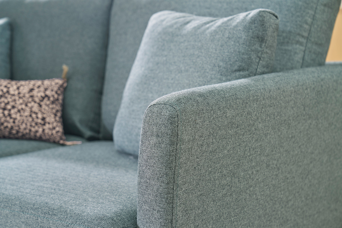 Canap� scandinave 2 places vert de gris en tissu, accoudoir et coussins visibles.