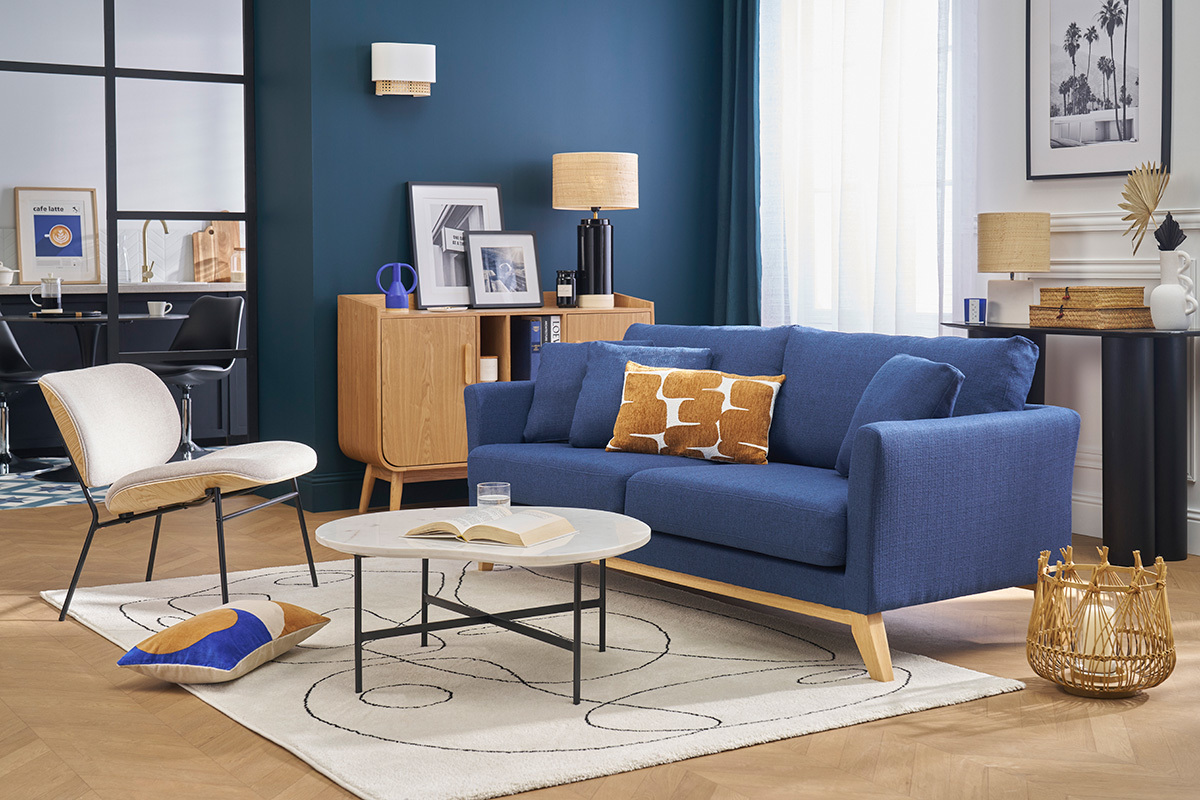 Canap� scandinave bleu 3 places avec coussins, vue de face dans un salon moderne.