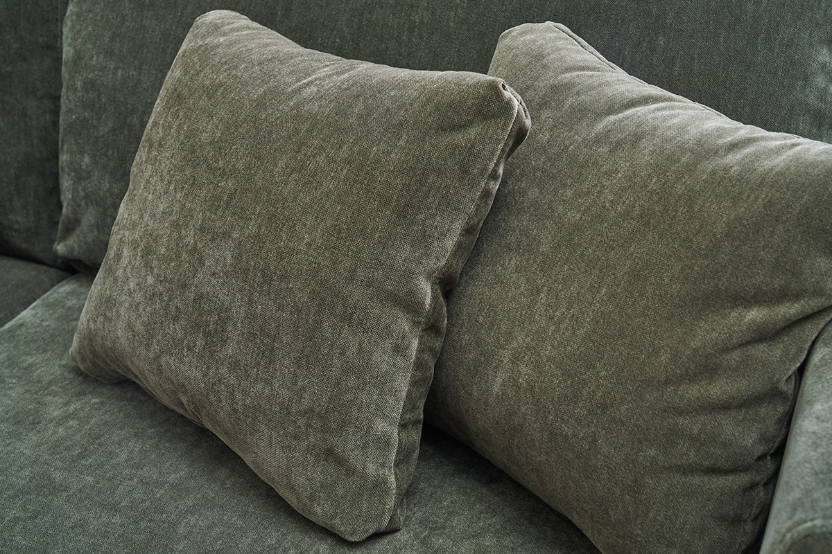 Gros plan sur les coussins du canap� en tissu vert kaki effet velours.