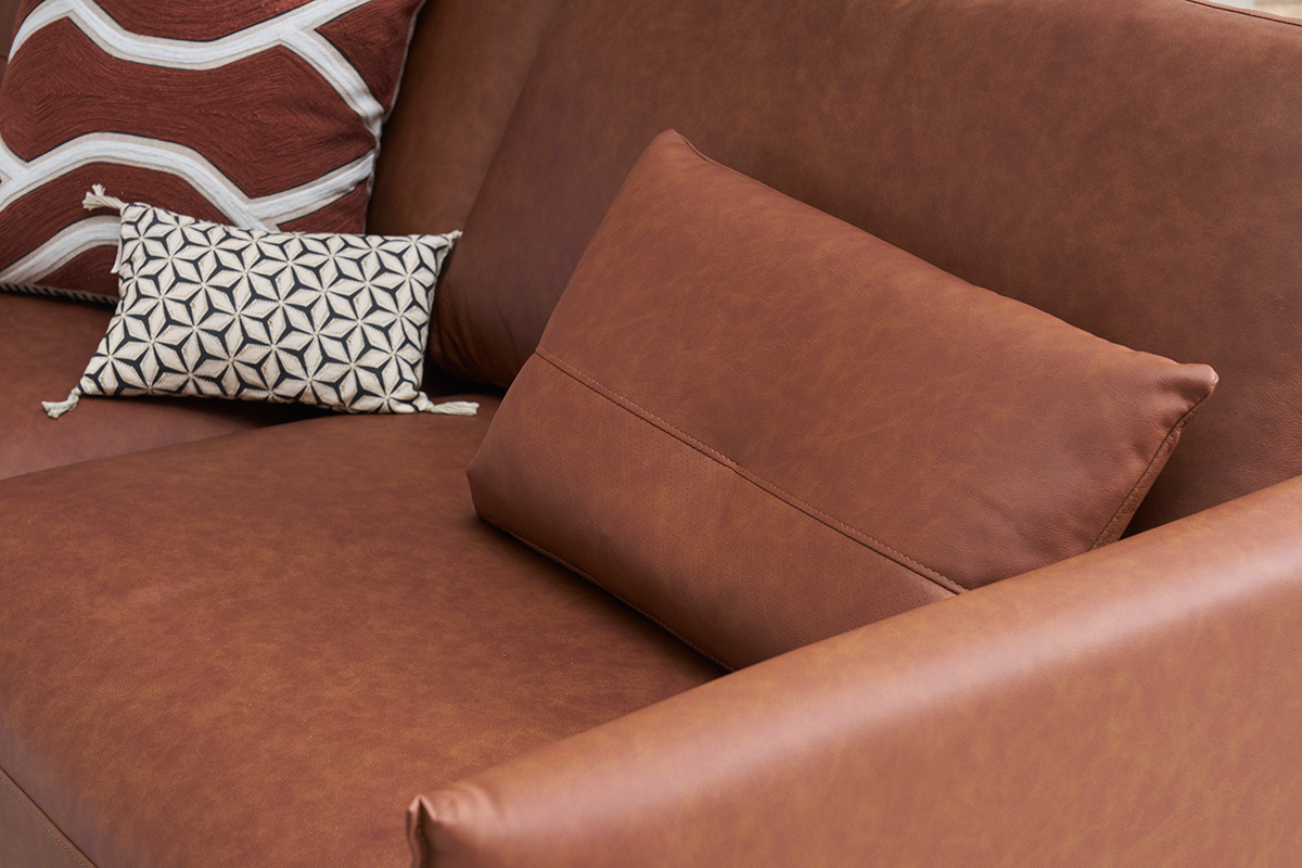 Vue rapproch�e d'un canap� en cuir marron avec coussins d�coratifs.