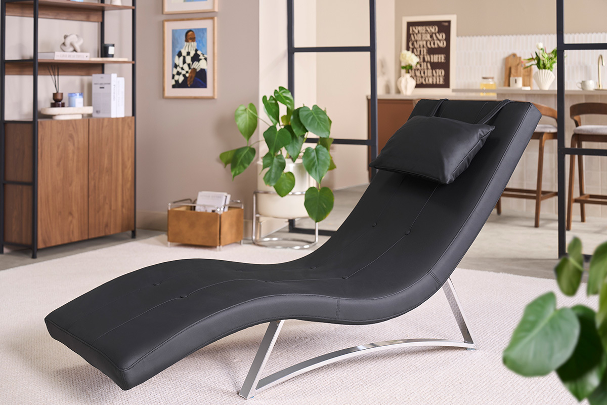 Chaise longue design noire avec coussin sur un pi�tement en acier chrom�, vue de trois quarts