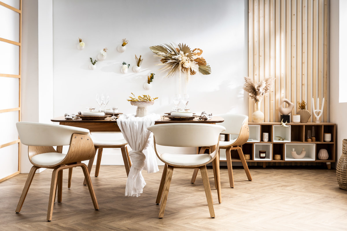 Chaises scandinaves blanches et bois autour d'une table en bois dans une salle � manger lumineuse.