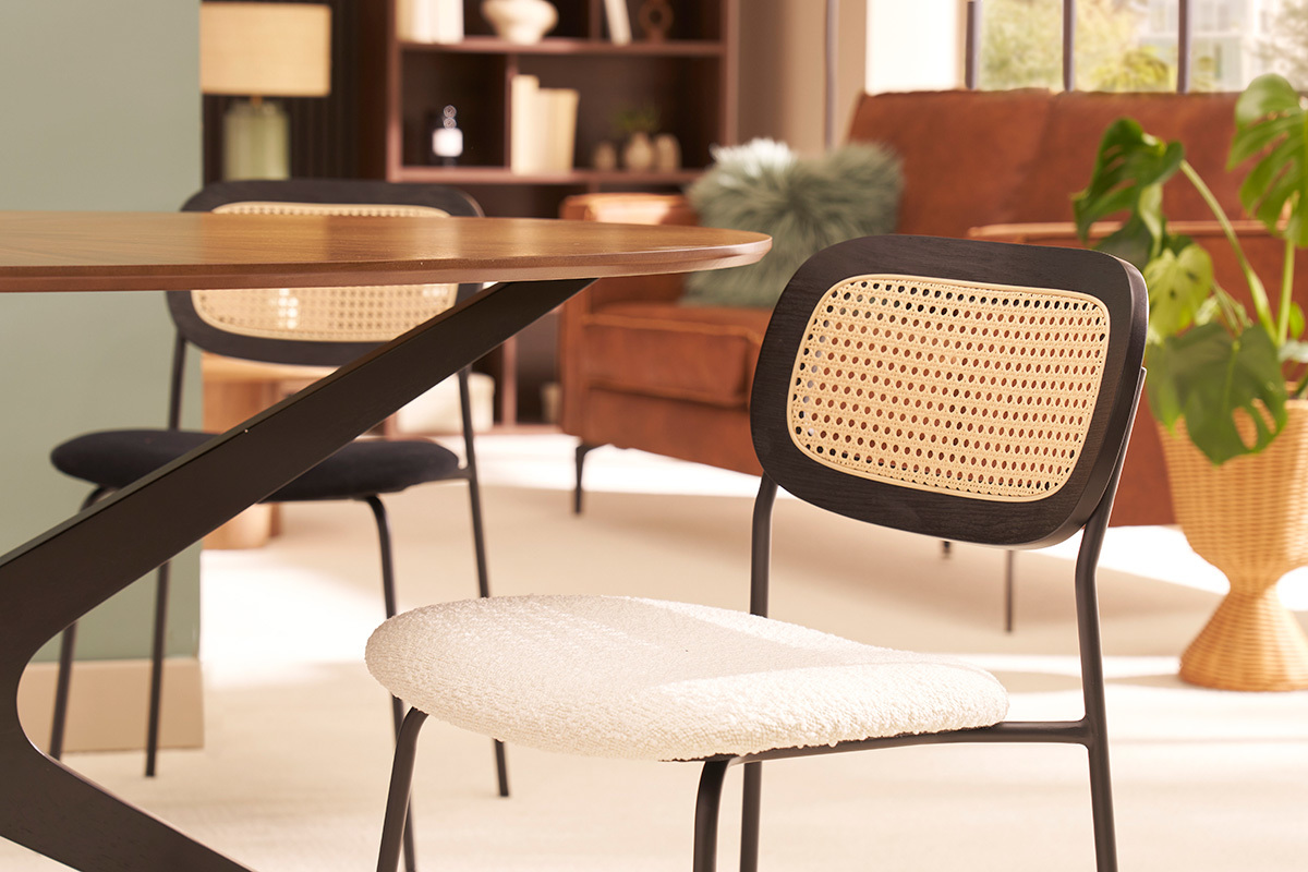 Chaises blanches en tissu effet laine boucl�e, dossier en rotin, pieds m�tal noir, pr�s d'une table en bois.