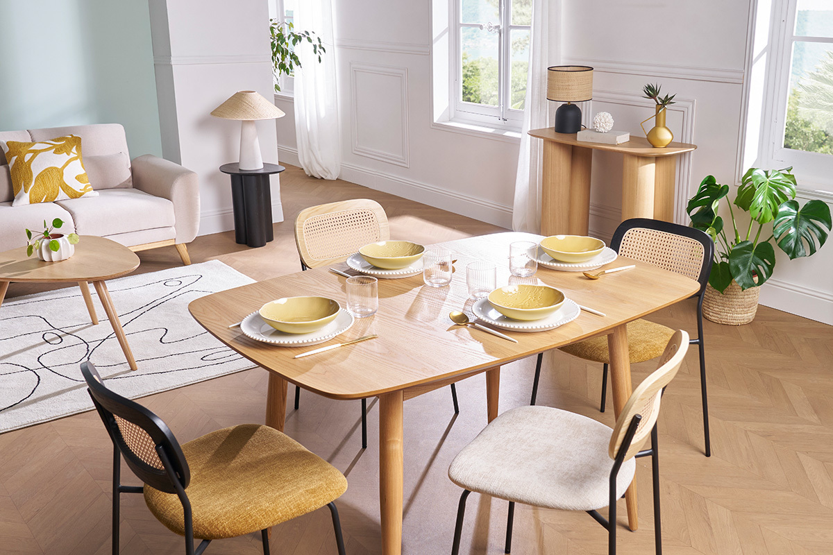 Salle � manger avec chaises MIRANDA en tissu bronze, cannage rotin et m�tal noir autour d'une table en bois.