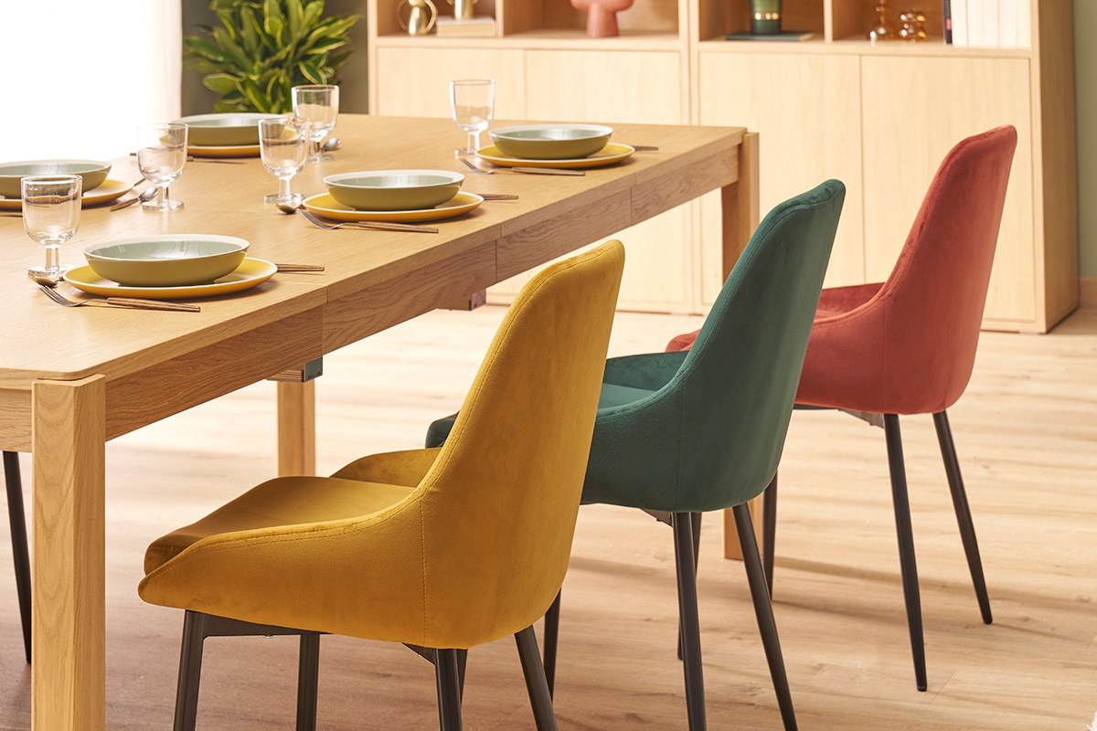 Chaises en velours et m�tal autour d'une table � manger en bois, vue lat�rale.