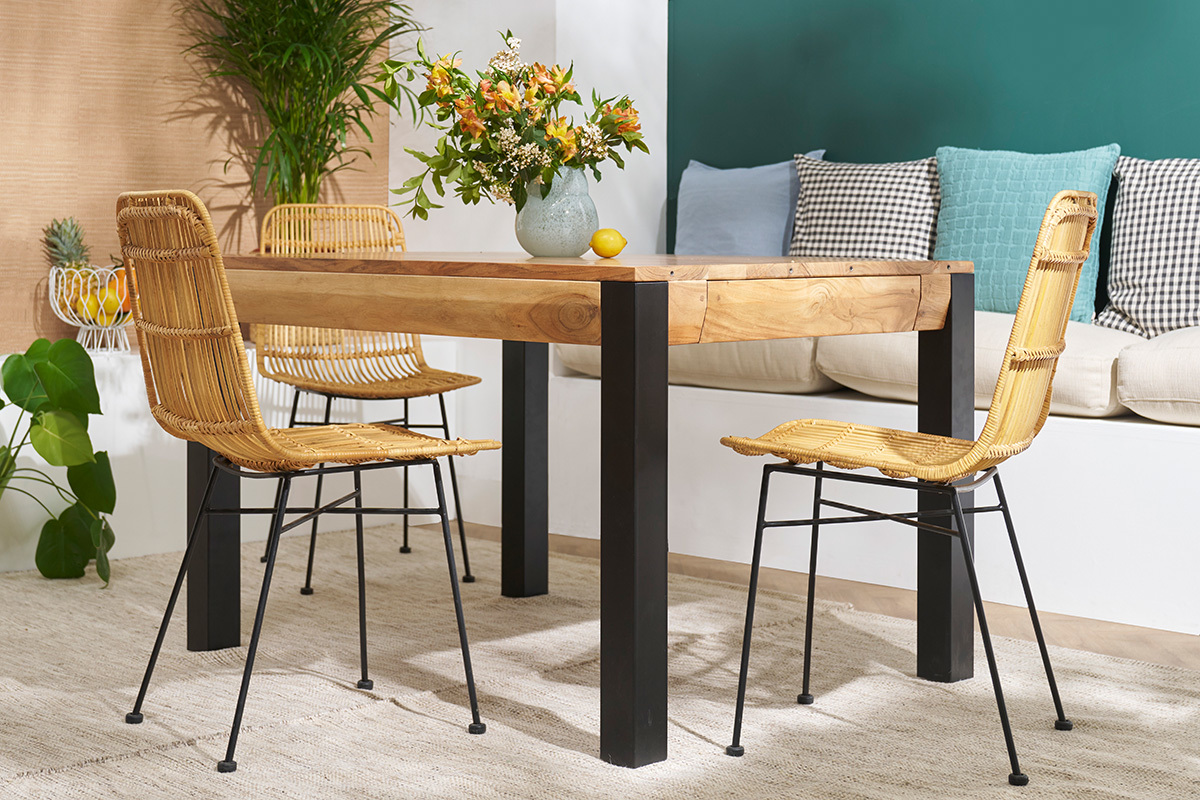 Deux chaises en rotin et m�tal noir autour d'une table en bois dans un salon.