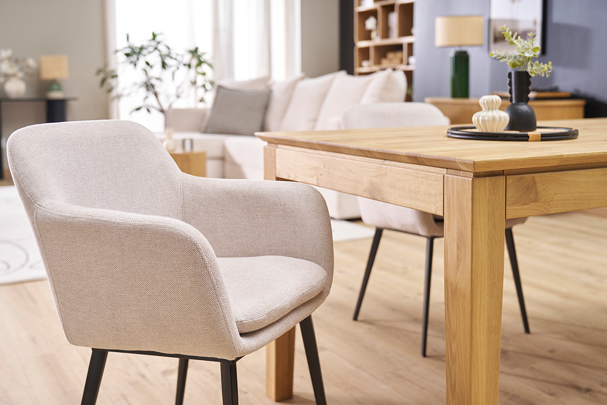 Chaises en tissu beige effet velours et m�tal noir, autour d'une table en bois dans un salon contemporain.