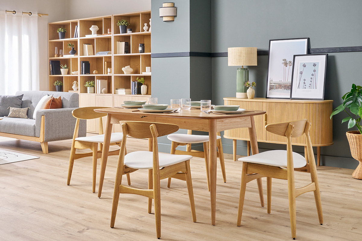 Salle � manger avec chaises scandinaves bois clair et blanc autour d'une table en bois.
