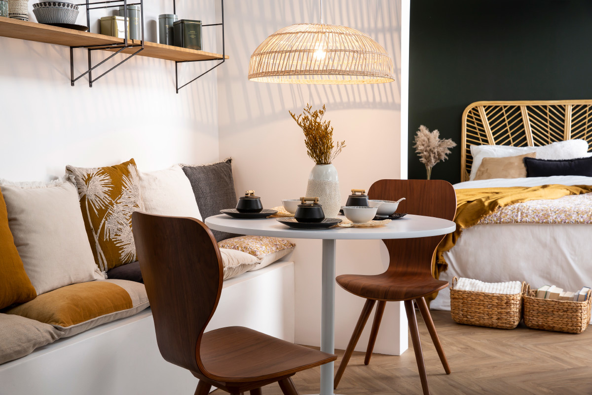 Chaises vintage en bois fonc� noyer autour d'une table blanche, dans un espace repas lumineux.