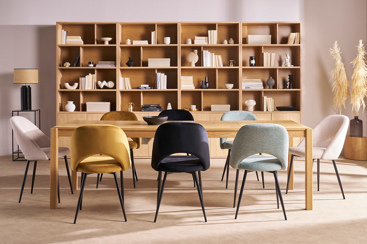 Chaises vintage en tissu beige et m�tal noir autour d'une table en bois, vue d'ensemble.