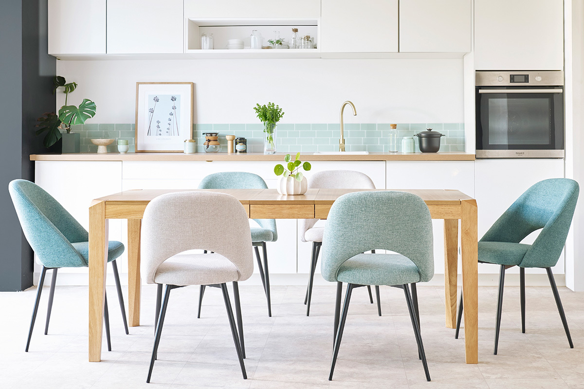 Salle � manger avec 4 chaises en tissu vert c�ladon et gris, table en bois, vue de face.