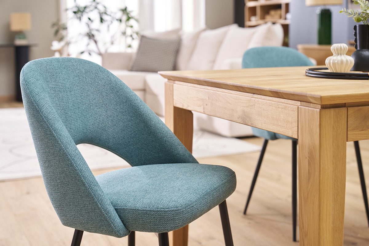 Chaises vintage vert de gris avec pieds en m�tal noir, � c�t� d'une table en bois.
