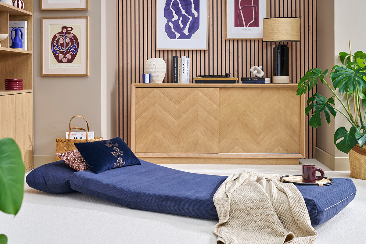 Chauffeuse convertible bleue SPENCER d�pli�e dans un salon moderne.