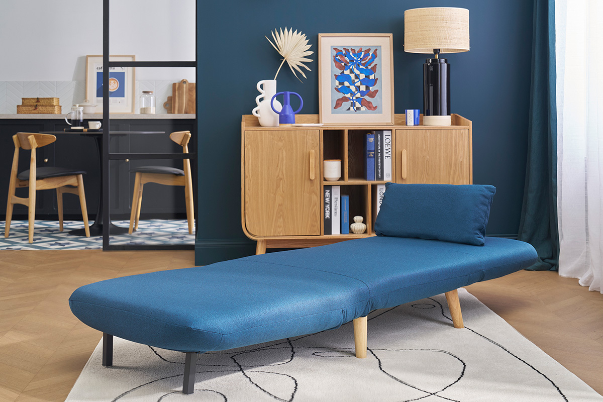 Fauteuil convertible bleu fonc� AMIKO d�pli� dans un salon scandinave.