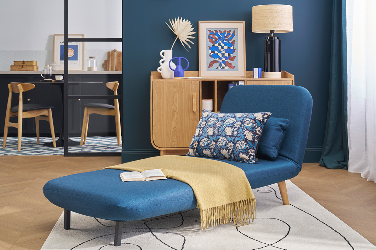 Fauteuil convertible AMIKO bleu fonc� sur fond de d�co scandinave, vue de profil.