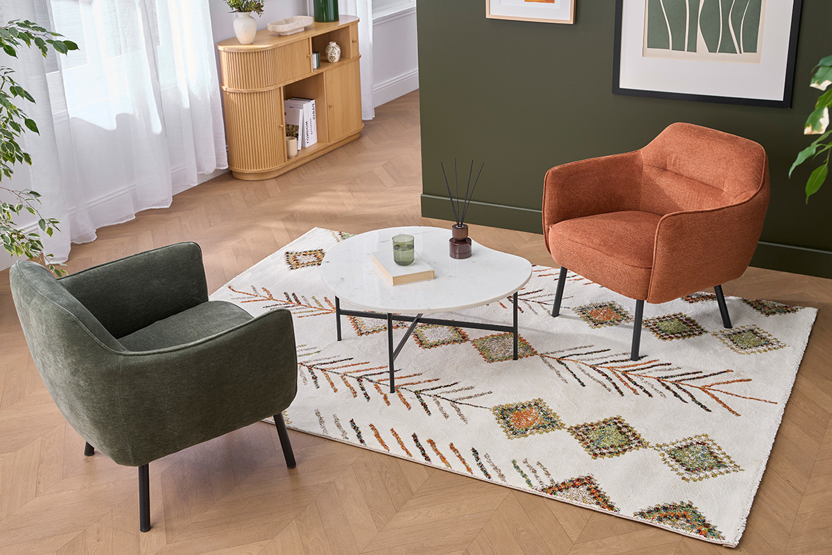 Fauteuil LAURENS terre br�l�e et m�tal noir, vue de haut, dans un salon moderne avec tapis et table basse.