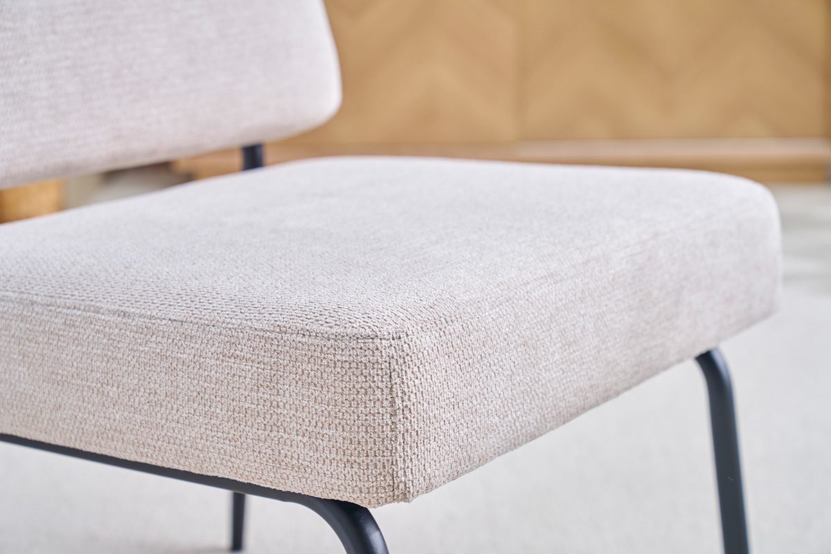 Fauteuil en tissu chenille beige et m�tal noir, vue rapproch�e.