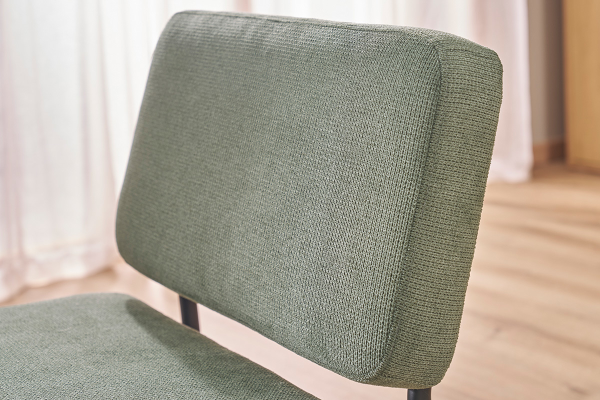 D�tail du dossier d'un fauteuil en tissu chenille vert kaki.