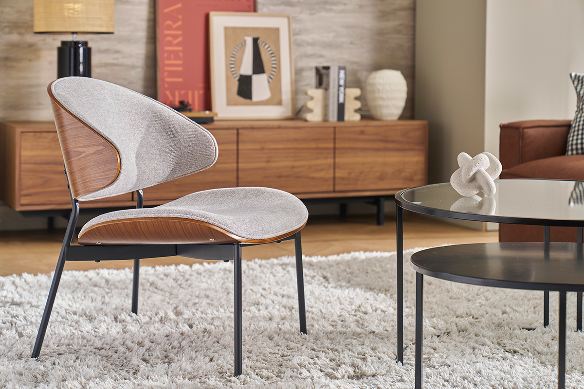 Fauteuil en tissu gris, bois fonc� et m�tal noir dans un salon moderne.