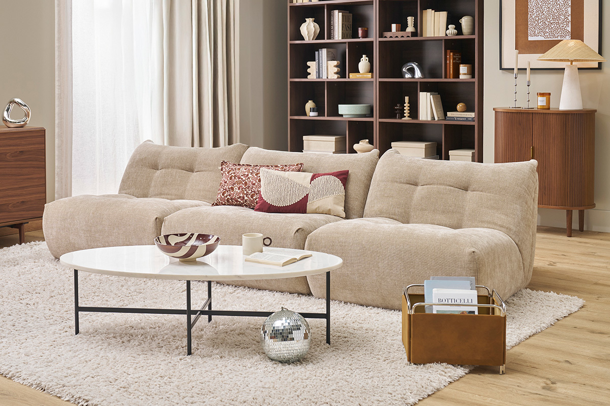 Fauteuil lounge en tissu velours taupe dans un salon �l�gant avec table basse blanche.