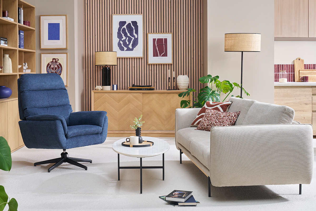 Fauteuil pivotant bleu JONAH dans un salon moderne avec canap� beige et table ronde.