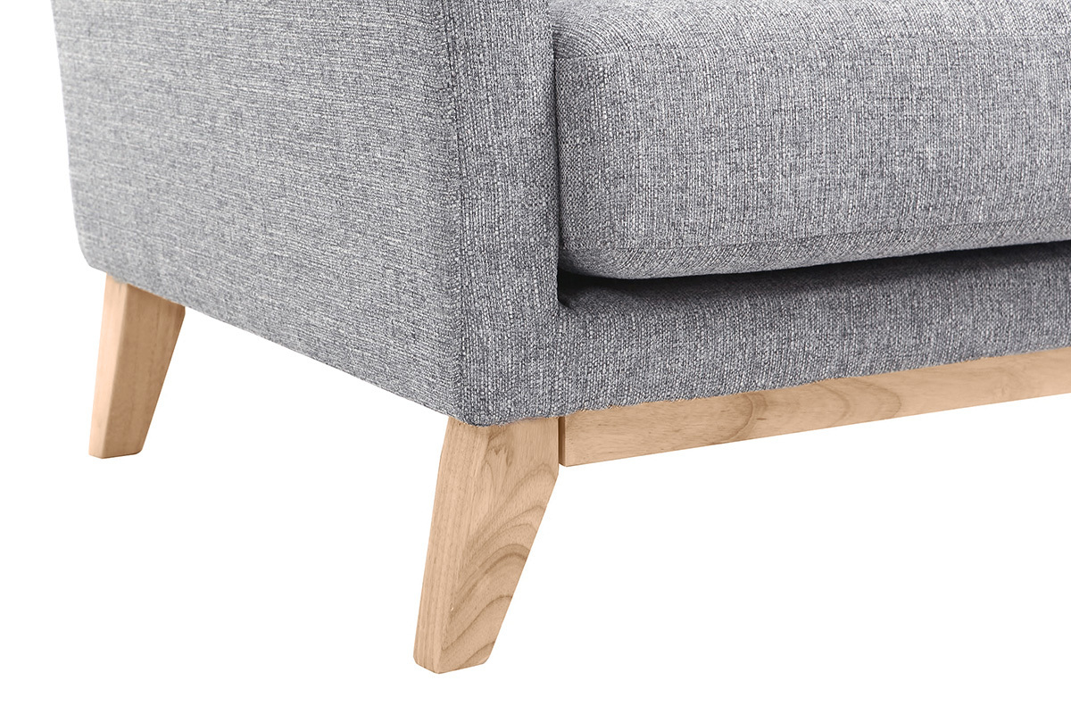 Gros plan sur le coin d'un fauteuil scandinave en tissu gris clair et bois clair.
