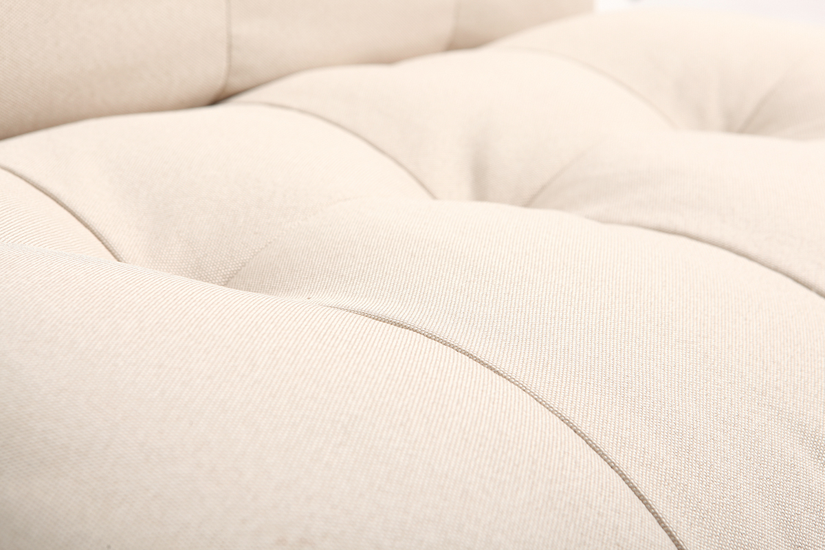 Gros plan sur l'assise �paisse du fauteuil scandinave beige YUMI avec capitons.