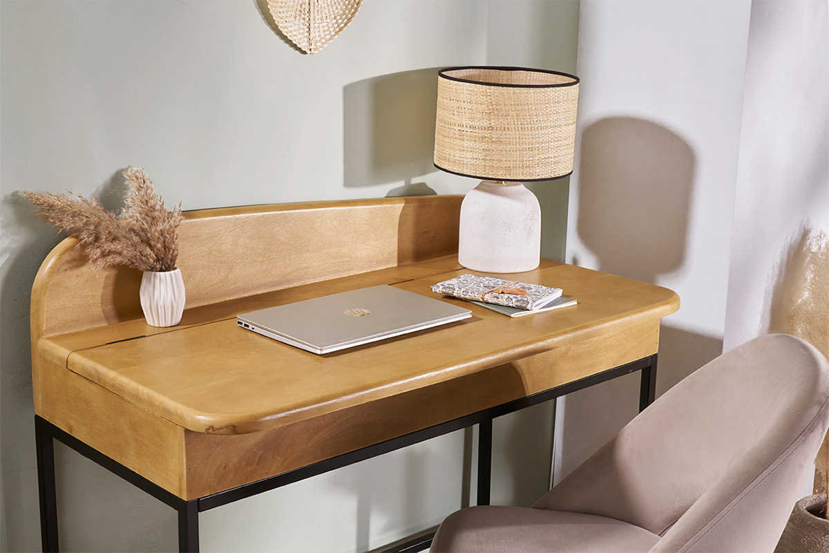 Lampe � poser blanche en c�ramique avec abat-jour en raphia sur un bureau en bois, vue de 3/4.